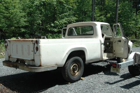 1963 Ford F-250 - This white Ford pickup truck, likely from the late 1950s, is shown from the rear with its doors ajar.