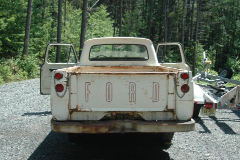 1963 Ford F-250 - Rear view of a white 1963 Ford F-250 pickup truck with its doors open.