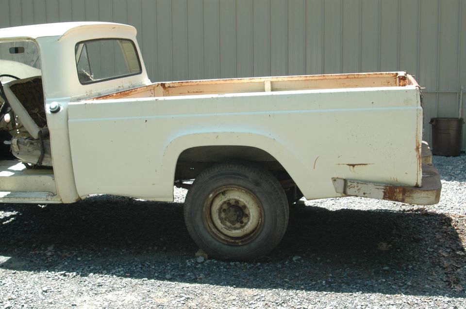 White pickup truck, side view, showing rust and wear