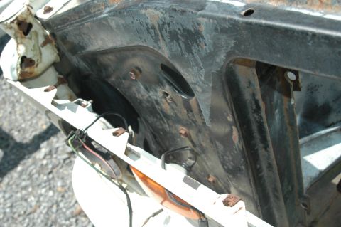 1963 Ford F-250 - Close-up of the inner fender well on a 1963 Ford F-250, revealing signs of rust and exposed wiring.