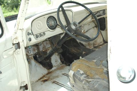 1963 Ford F-250 - The interior of a 1963 Ford F-250 pickup truck, a worn dashboard and driver's seat.