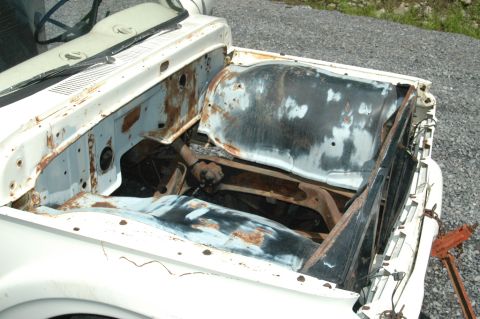 1963 Ford F-250 - The engine bay of a 1963 Ford F-250 shows significant rust and wear, indicating it is a donor truck.