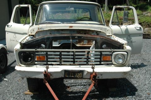 1963 Ford F-250 - Front view of a white 1961 Ford F-series truck, hood removed, doors open, showing its grille and front end.