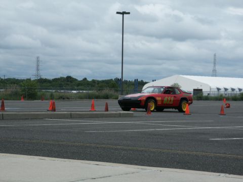 2001 Mercury Grand Marquis - A red sports car with yellow wheels and racing numbers participates in an autocross event.