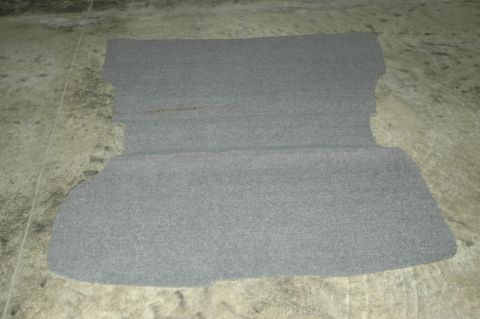 1993 Ford Mustang - A gray carpet piece, possibly from a car's trunk or interior, lies on a concrete surface.
