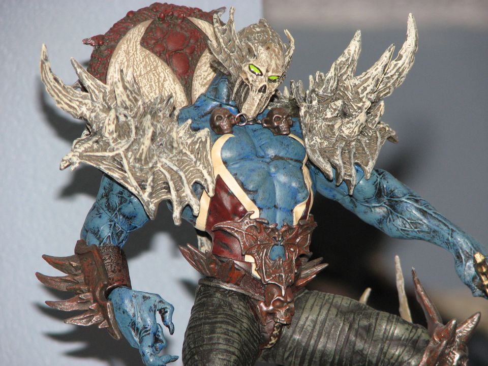 Close-up of a blue-skinned action figure with a skull mask and spiky armor