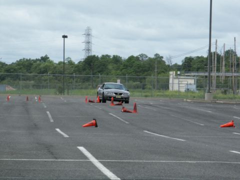 2001 Mercury Grand Marquis - Silver sedan navigates an autocross course marked by orange cones. The vehicle appears to be a Ford Mustang from the early 2000s.