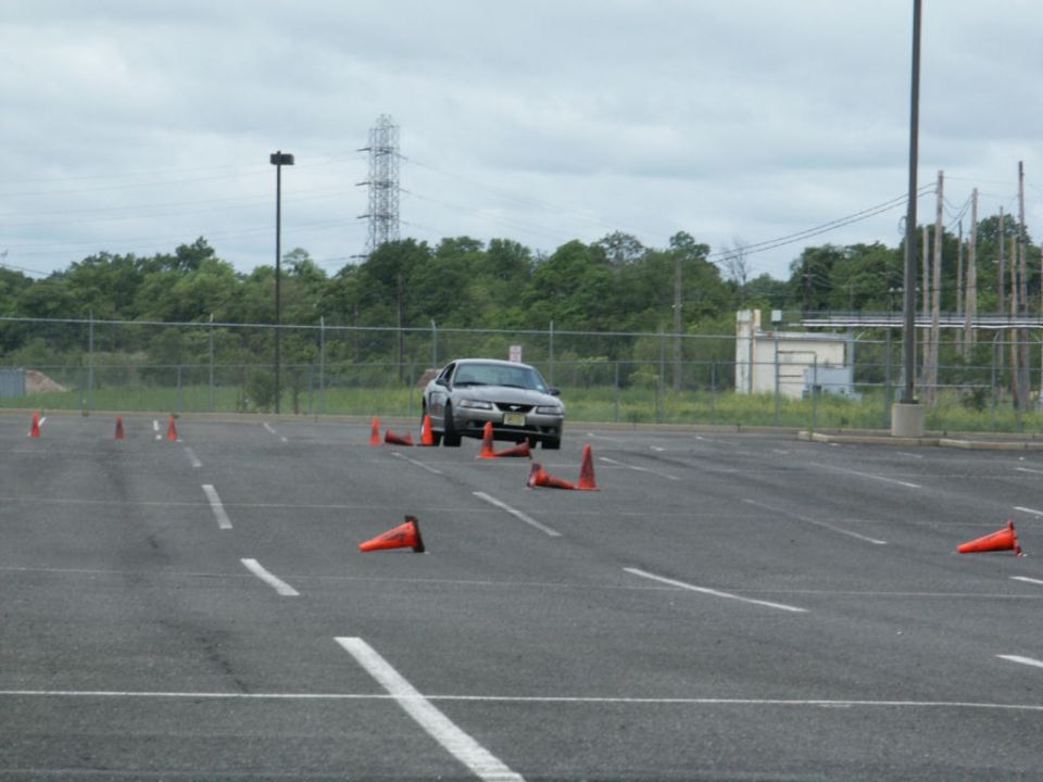 Silver sedan on cone course, 3q-front view. Registry claims 2001 Mercury Grand Marquis