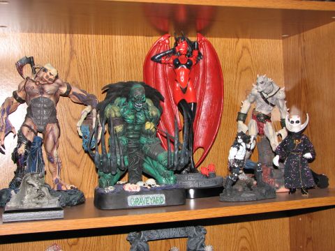 1991 Ford Bronco - A collection of fantasy and horror-themed figurines are displayed on a wooden shelf.