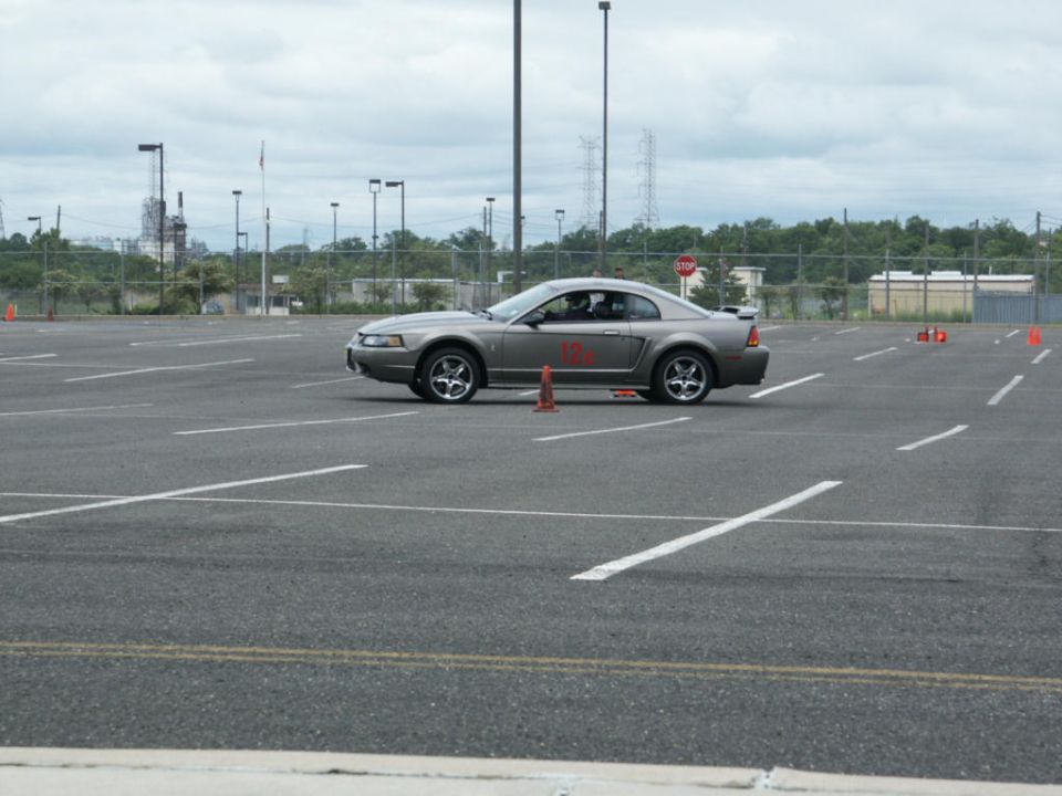 Silver coupe with red racing numbers on side, seen from side