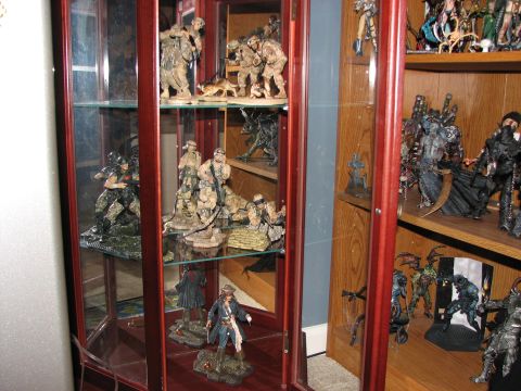 1991 Ford Bronco - A collection of action figures is displayed on shelves inside a wooden and glass cabinet.