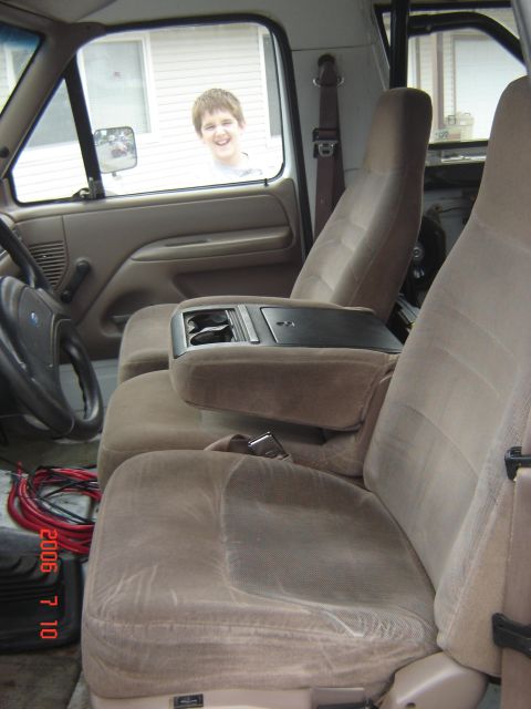 1993 Ford Bronco - The interior of a 1992 Ford F-250 truck is visible, with a boy looking in through the window.