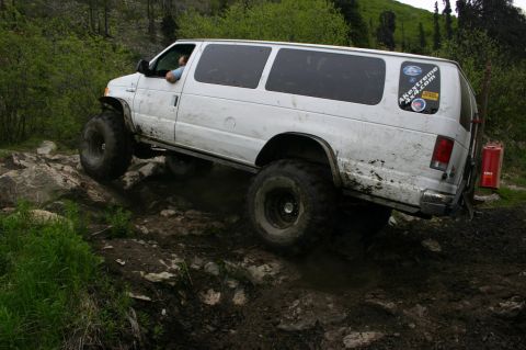 2003 Jeep TJ - A white van navigates a challenging off-road course with steep inclines and loose terrain.