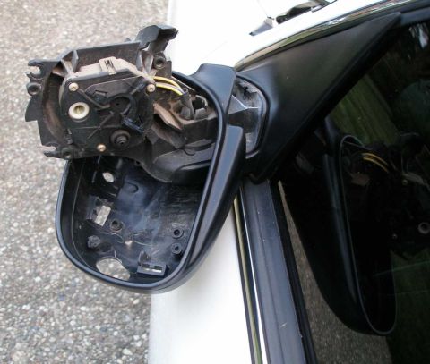 2001 Ford Crown Victoria - Driver's side mirror assembly disassembled, showing internal wiring and motor components.