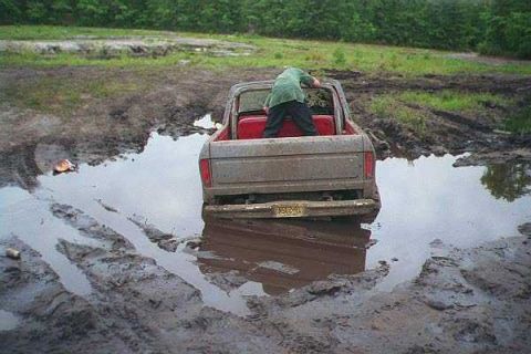 1990 Ford Bronco - Truck is stuck in the mud after driving through a wet, grassy area.