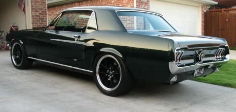 1965 Ford Mustang - Rear view of a dark green 1966 Ford Mustang coupe with custom wheels.