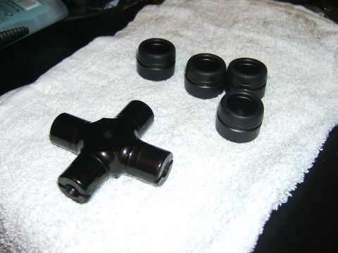 1993 Ford Bronco - A black universal joint and four black bearing caps are laid out on a white towel.