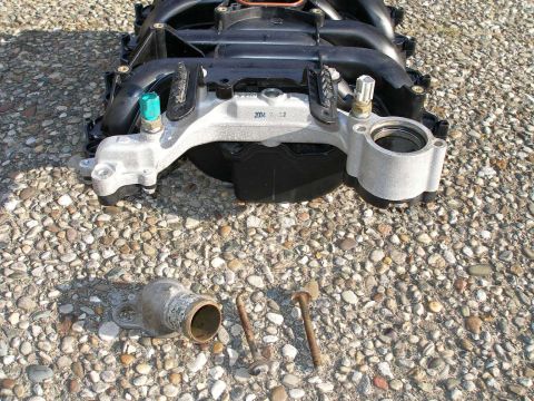 1998 Ford Crown Victoria - Engine intake manifold and associated parts laid out on a gravel surface.