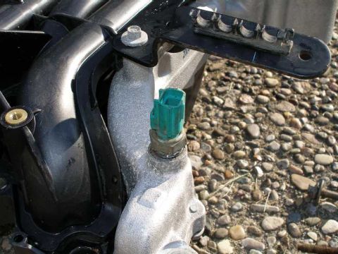 1998 Ford Crown Victoria - Close-up of an intake manifold part with a green sensor attached.