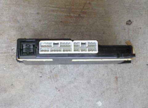 1998 Ford Crown Victoria - An automotive electronic control module with multiple white connectors is shown against a concrete background.