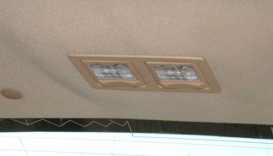 Dual rear courtesy lamps in tan bezel mounted in a tan headliner