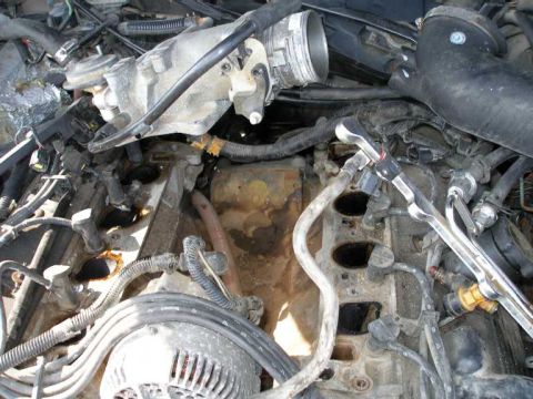 1998 Ford Crown Victoria - Close-up view of a disassembled engine bay, showing various mechanical components and wiring.