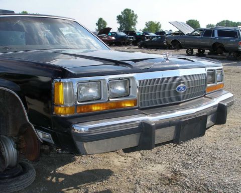 1998 Ford Crown Victoria - Junkyard Ford Crown Victoria shows its front end, with other cars in the background.