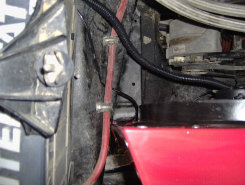 1978 Ford Bronco - Detail of engine bay components, including a red fluid reservoir and alternator.