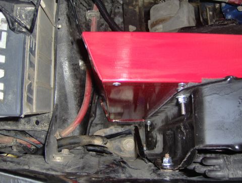 1978 Ford Bronco - Close-up of an engine bay with a red cover and battery visible.