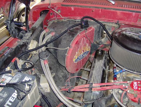 1978 Ford Bronco - Close-up of an engine bay showing various aftermarket parts and wiring, including a Ford-branded fan shroud.