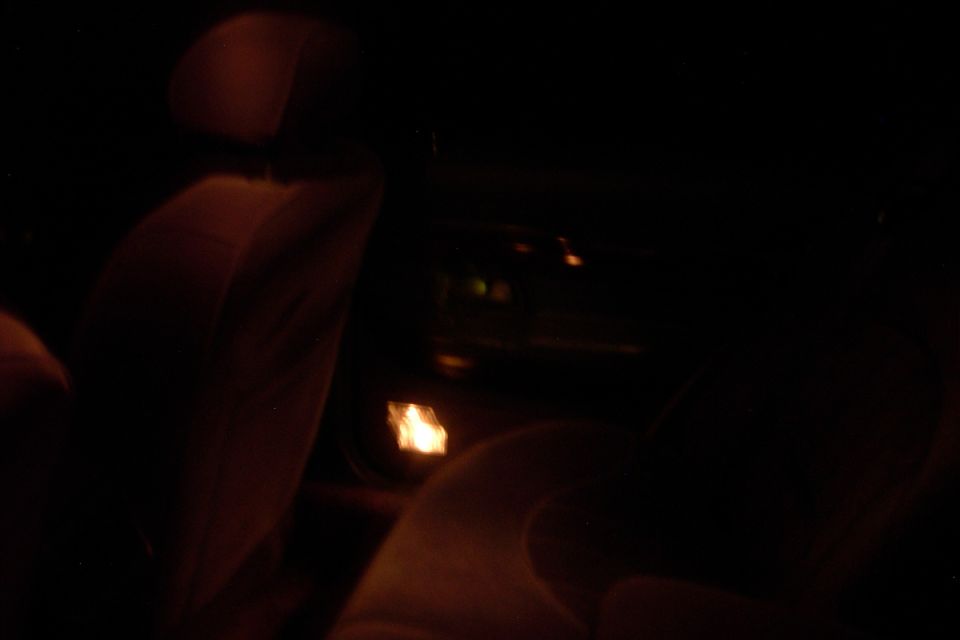 Dark car interior with light-colored front seats at night