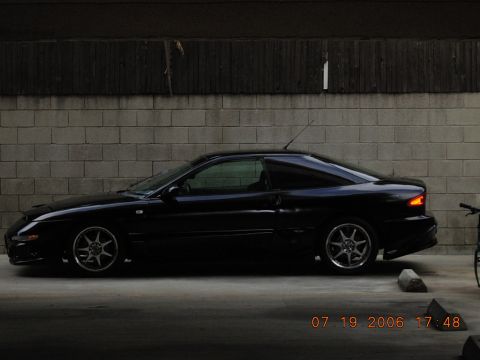 1993 Ford Probe - A black 1993 Ford Probe is seen from the side, parked in front of a brick wall with a timestamp overlay.
