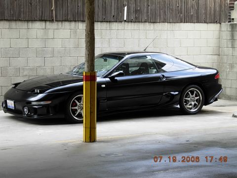 1993 Ford Probe - A black 1993 Ford Probe coupe is parked in front of a brick wall.
