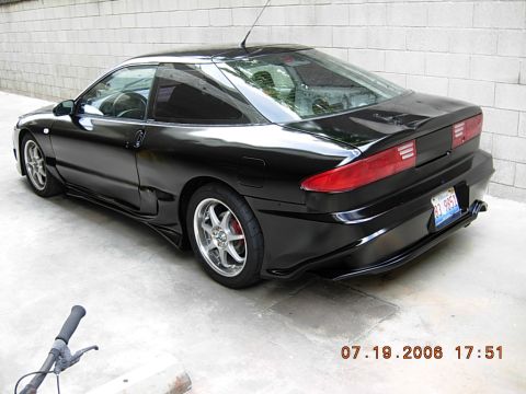 1993 Ford Probe - A black coupe is parked in front of a brick wall. The license plate is visible.
