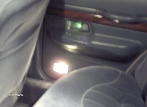 1996 Mercury Grand Marquis - Interior door panel detail showing wood trim and illuminated courtesy light.