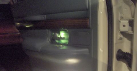 1996 Mercury Grand Marquis - Illuminated door handle glows green on the interior door panel of a 1996 Mercury Grand Marquis.