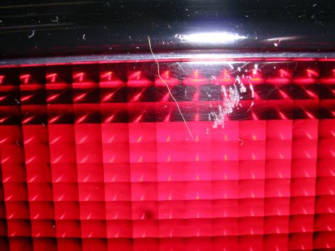 1996 Ford Probe - Close-up of a red taillight a checkered pattern and visible scratches.
