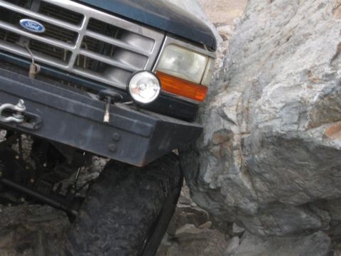 1994 Ford Bronco - This 1994 Ford Bronco is navigating a rocky trail, with its front bumper and tire firmly lodged against a large boulder.