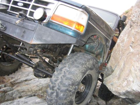 1994 Ford Bronco - This 1994 Ford Bronco is shown off-roading, with its front tire wedged against a large rock.