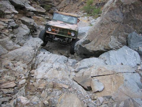1994 Ford Bronco - Ford Bronco tackling a difficult rocky path, demonstrating off-road capability.