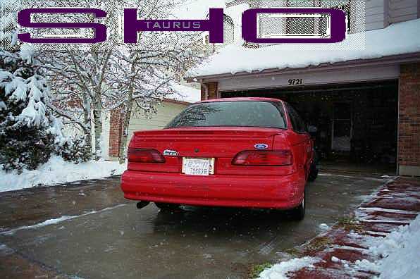 Red 1995 Ford Taurus SHO rear view in snowy driveway