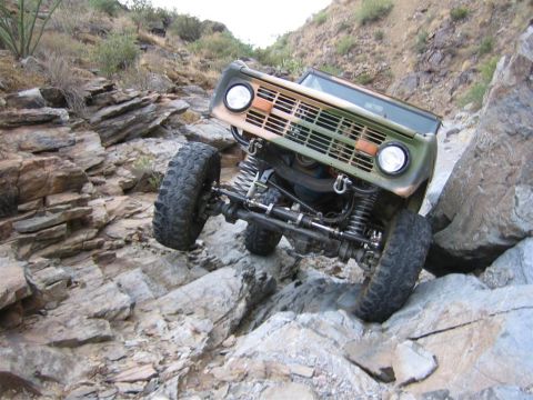 1994 Ford Bronco - This heavily modified Ford Bronco navigates a challenging rocky trail, its off-road capabilities.