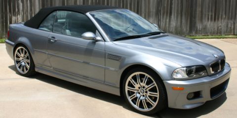 1988 Ford Crown Victoria LTD - A silver BMW M3 convertible is shown from the front quarter angle, parked outdoors.