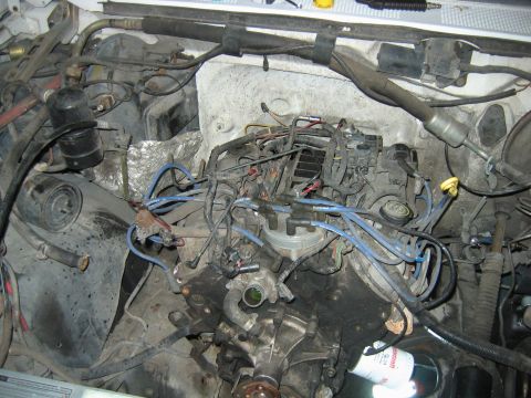 1992 Ford Bronco - The engine bay of a vehicle, showing numerous wires, hoses, and engine parts. The registry claims it is a 1992 Ford Bronco.