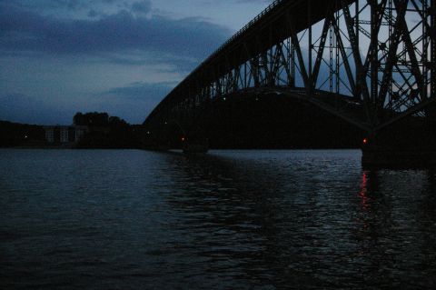 1998 Jeep TJ - A large bridge spans a body of water under a cloudy twilight sky, with buildings visible in the distance.