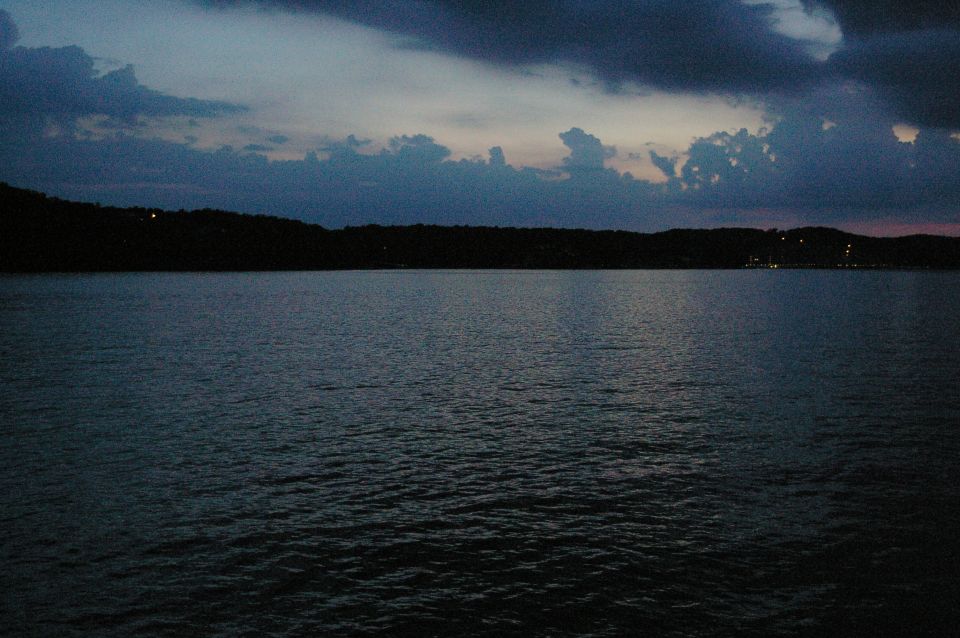 Lake and tree-lined shore under a cloudy dusk sky. Text overlay reads SUPERMOTORS