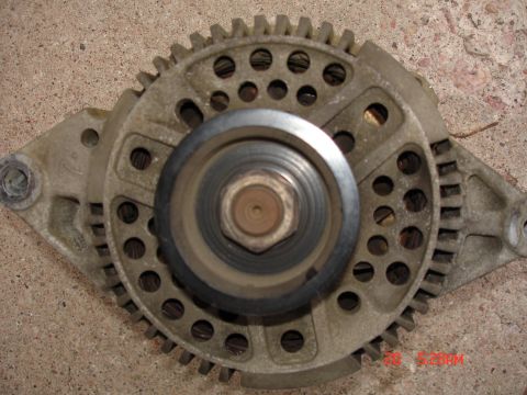 1979 Ford Bronco - This is a close-up view of an automotive alternator part, showing its pulley and surrounding gear-like structure.