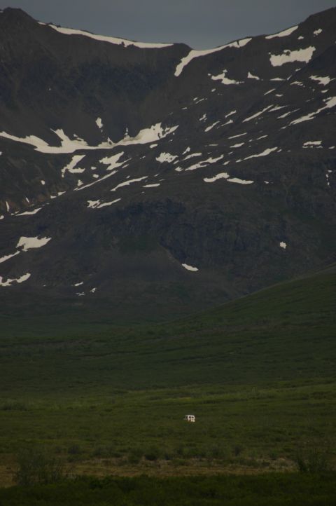 2003 Jeep TJ - A solitary structure stands in a wide, grassy plain against a backdrop of , snow-dusted mountains.