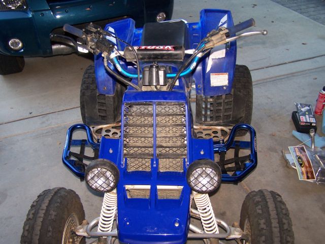 Front view of a blue Yamaha Banshee ATV with aftermarket nerf bars and headlights