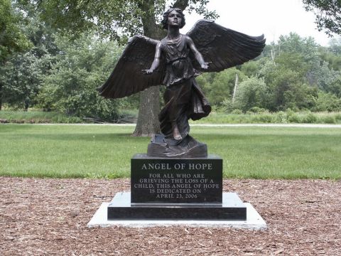 2001 Mercury Grand Marquis - A bronze statue of an angel with outstretched wings stands on a granite base inscribed with 'Angel of Hope'.